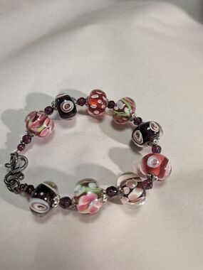 handmade bracelet features lampwork glass beads in reds/Purples 925 Clasp